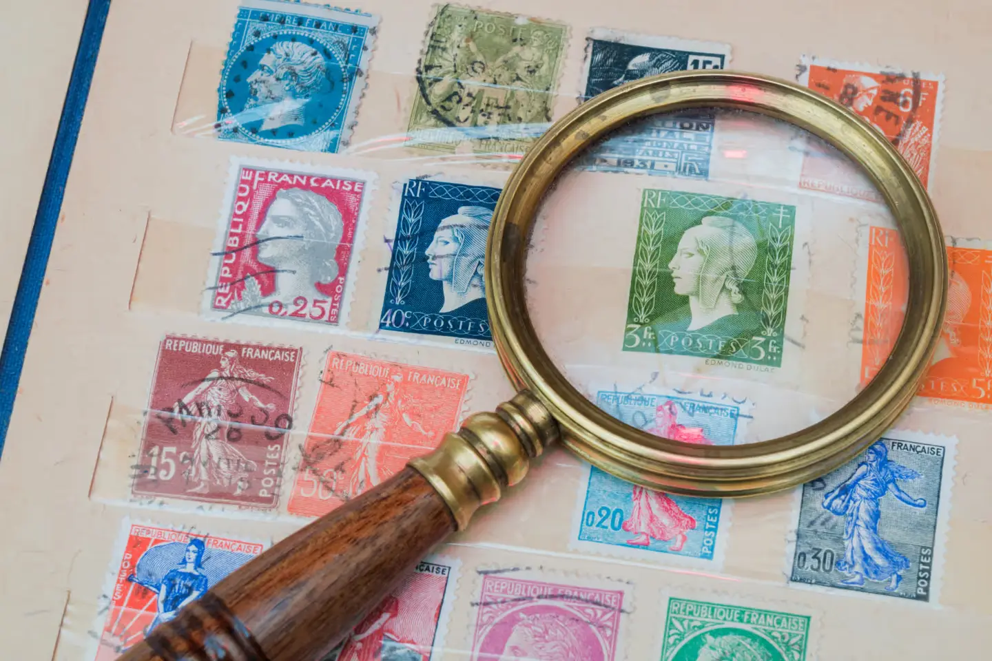 Magnifying glass over an album of stamps