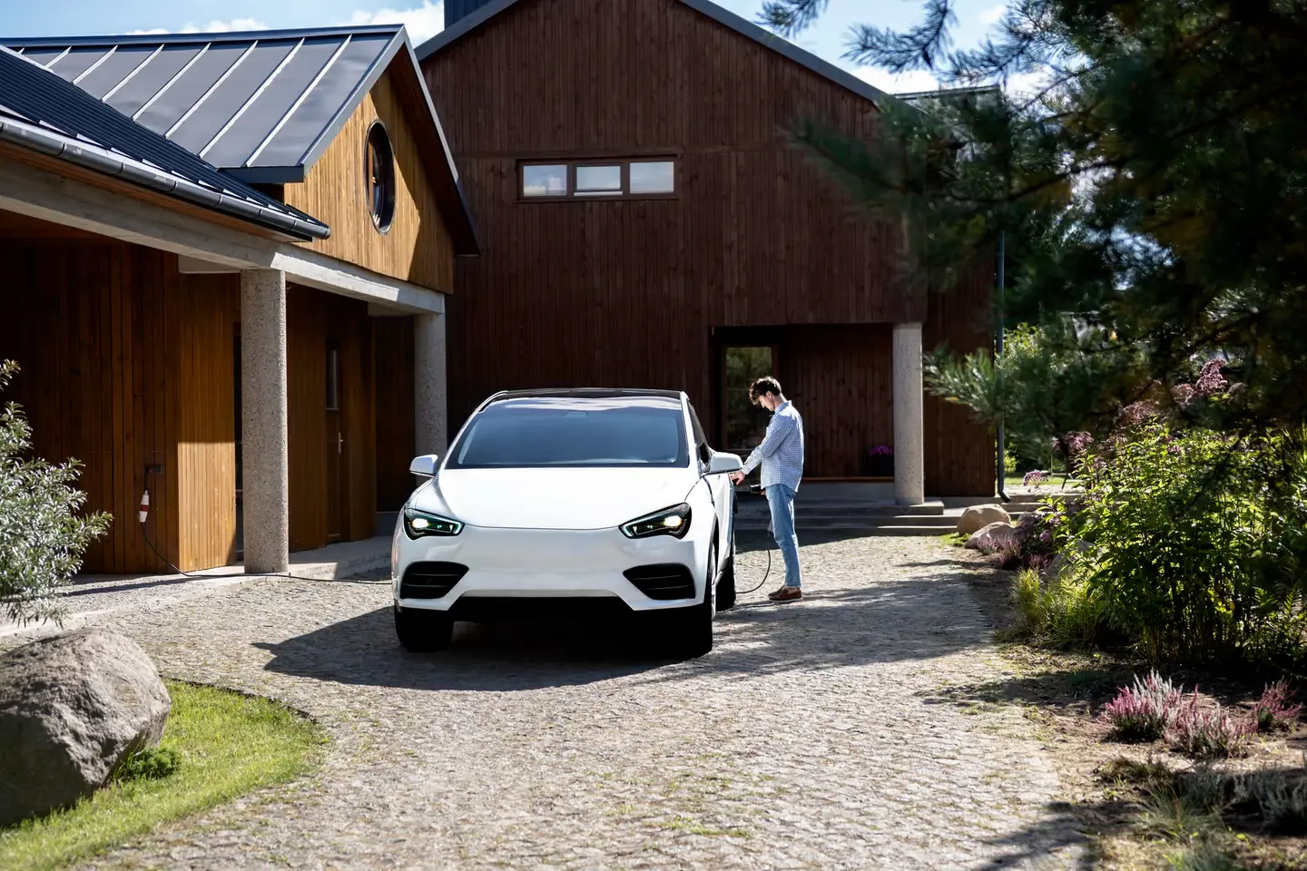 Car on the gravel drive of a timber-clad house