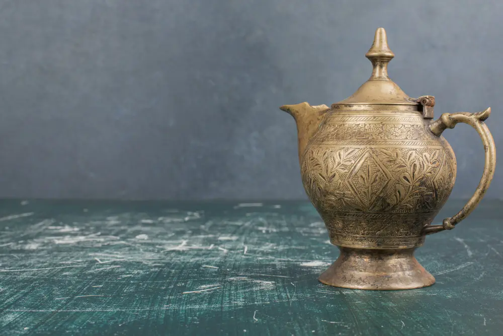 Engraved antique brass teapot on a table