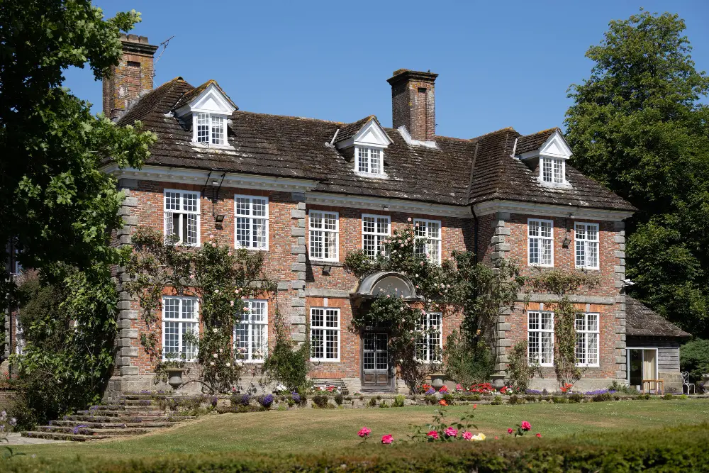 Georgian manor house with climbing roses and a lawn