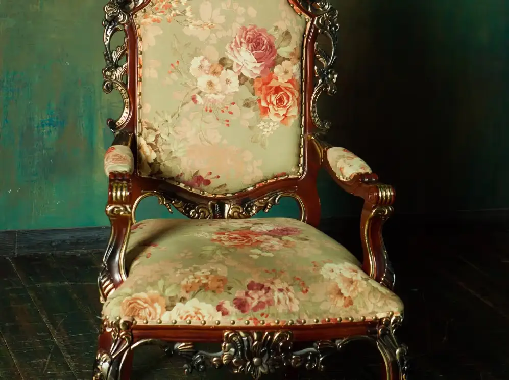 Antique armchair with carved wooden frame and floral upholstery