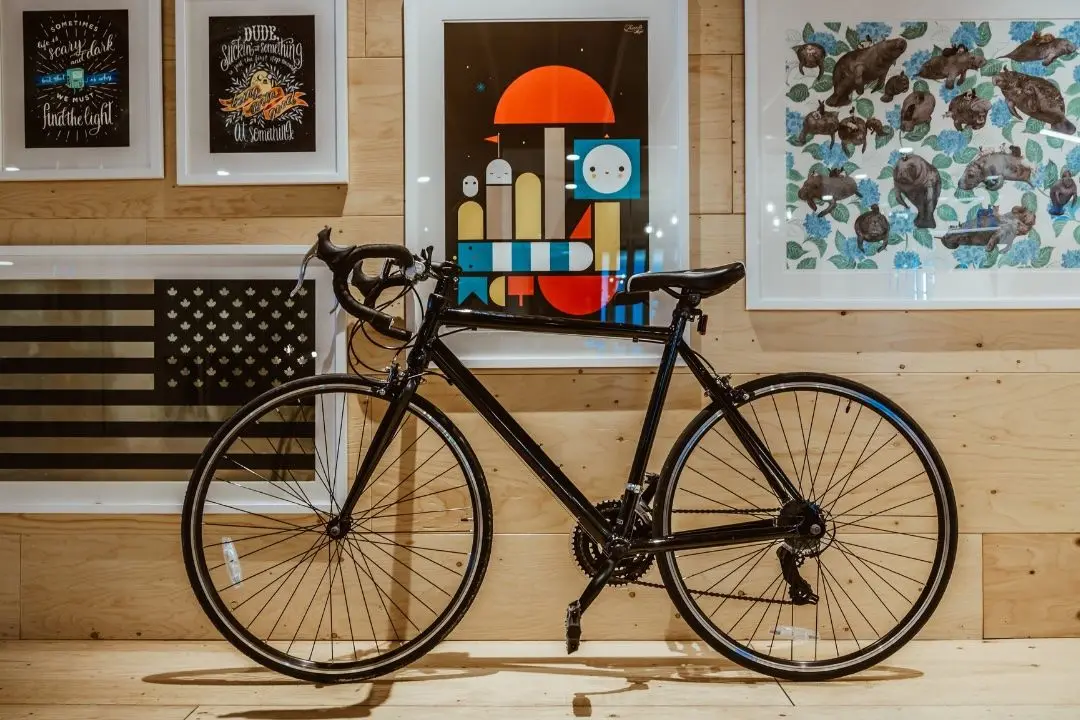 bicycle inside with flag and photos on wall