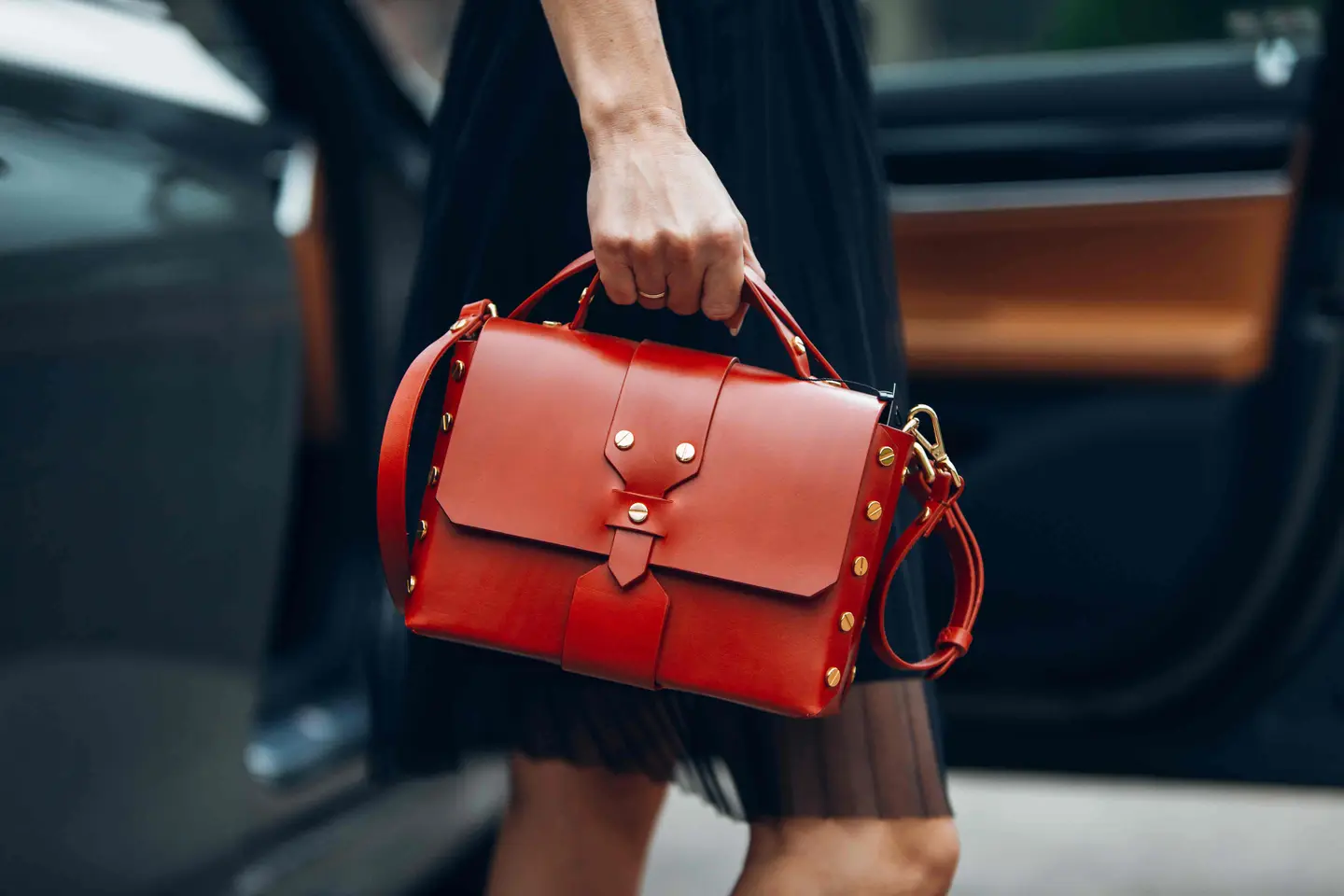 Woman carrying a red leather designer handbag