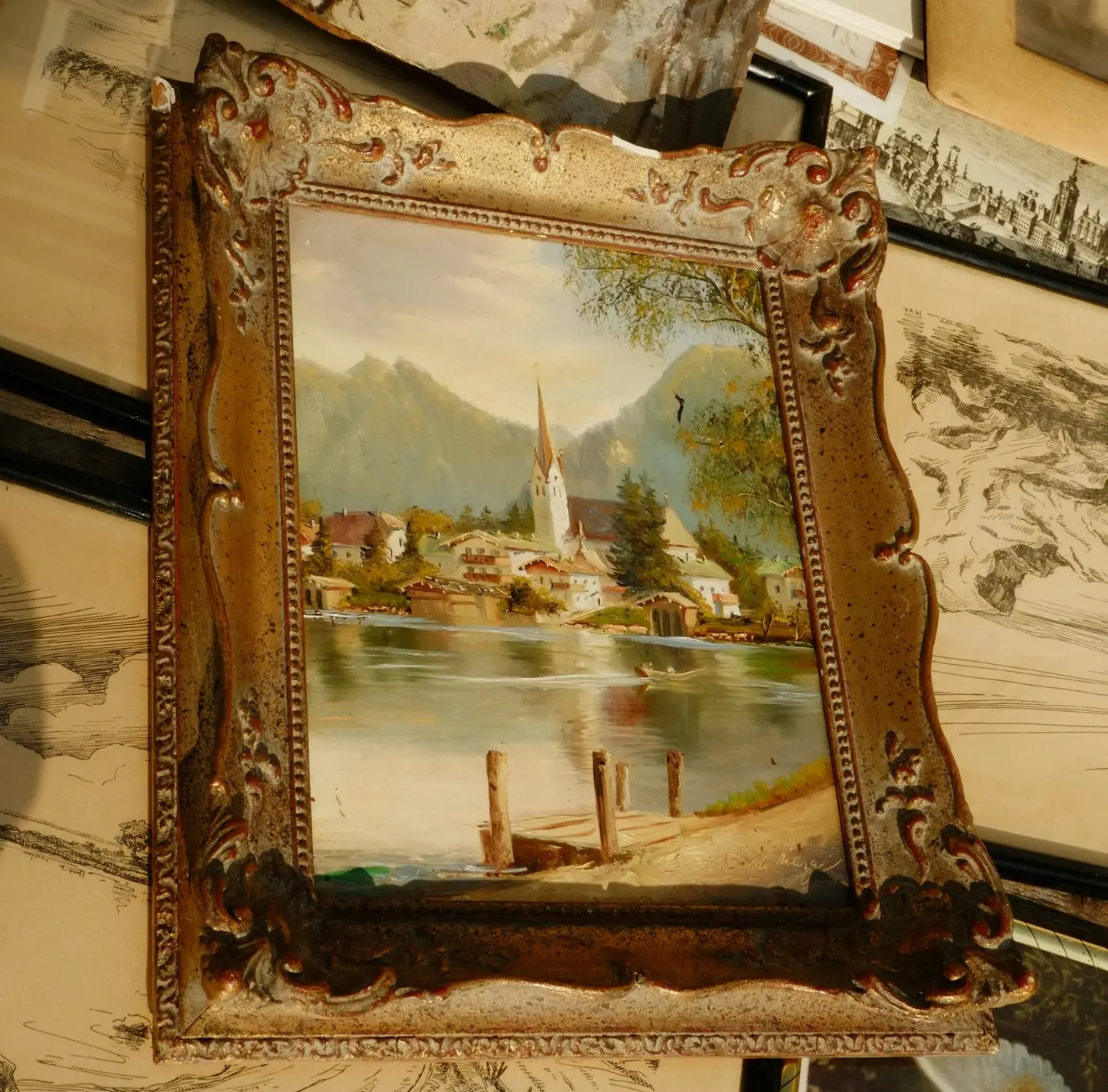 A landscape painting in an ornate gilt frame