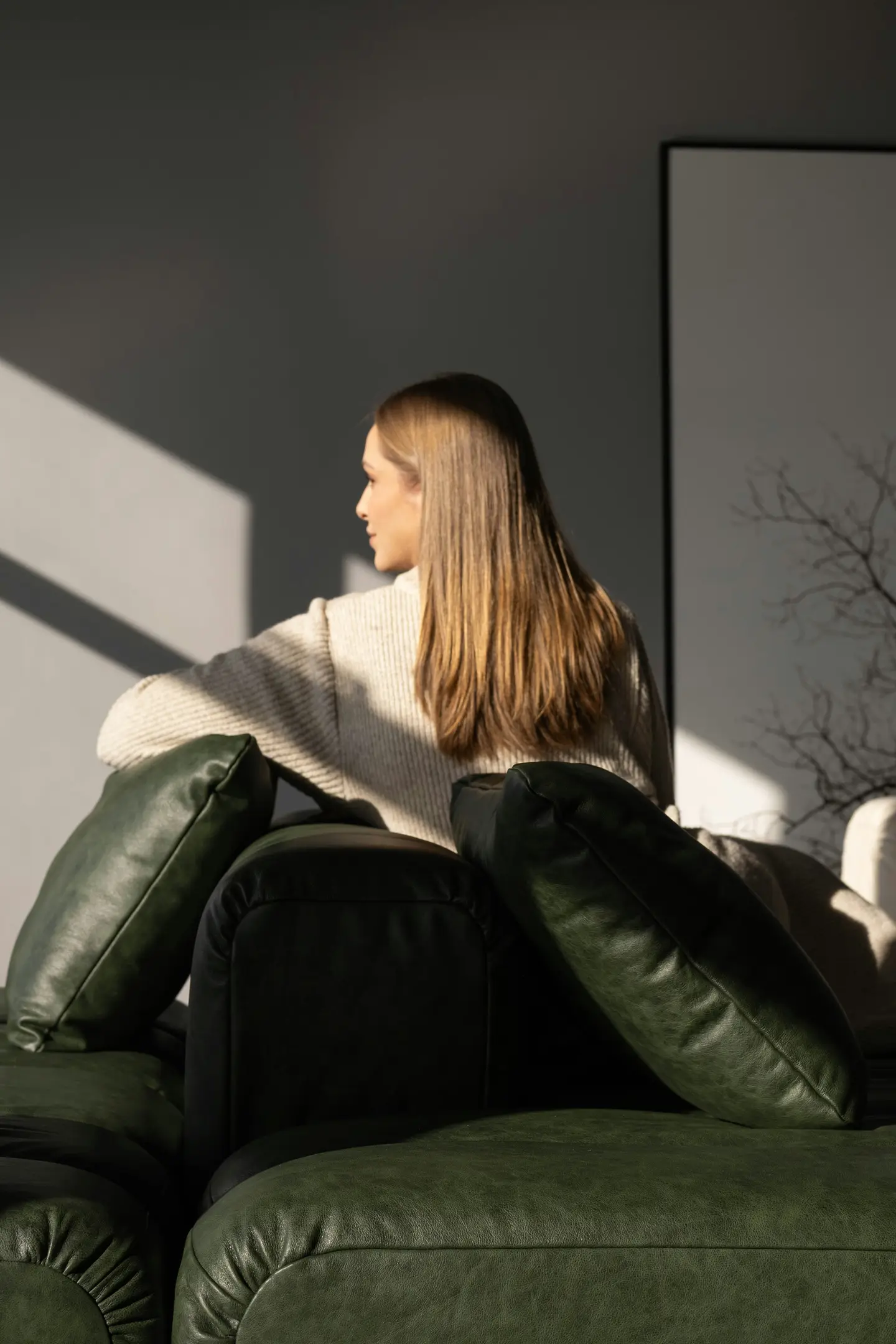 Woman relaxing on a green leather sofa