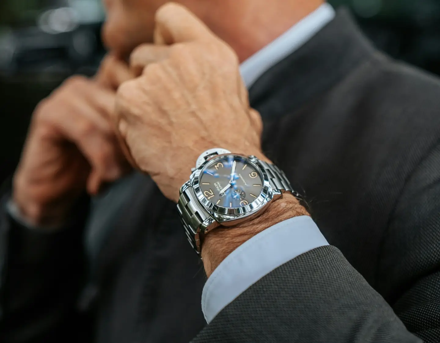 Man in a suit wearing a steel wristwatch